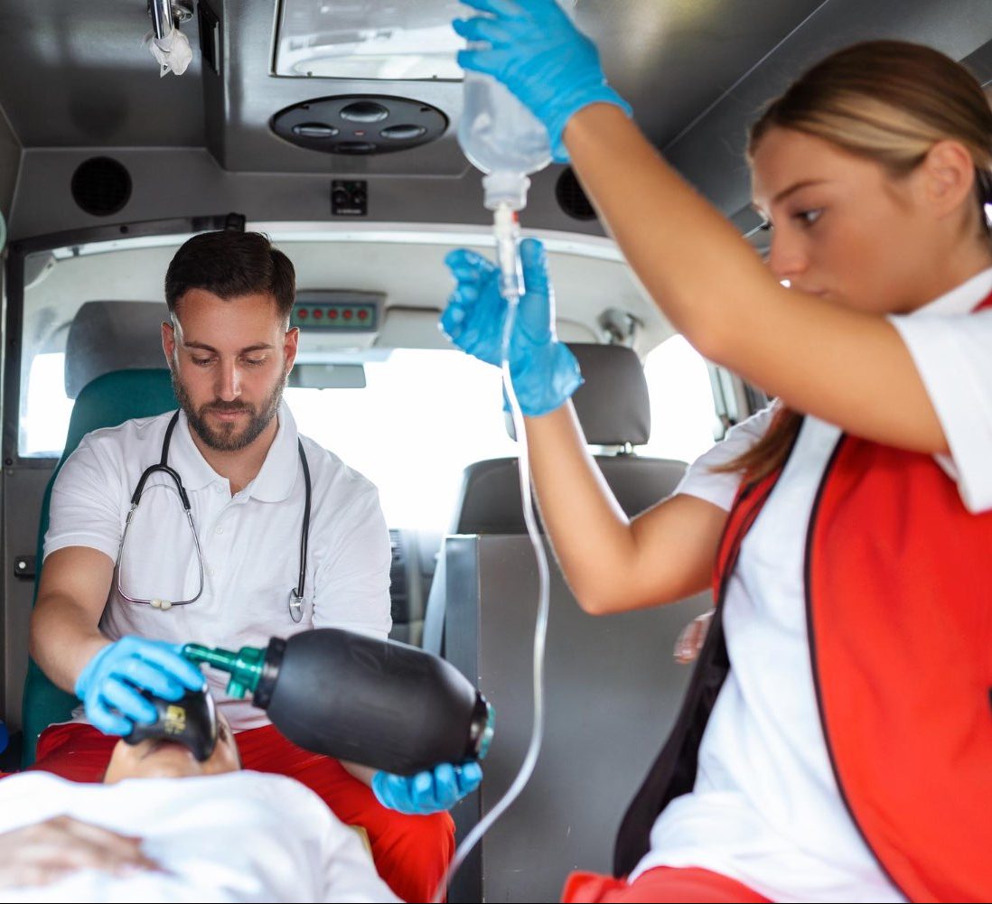 view from inside ambulance uniformed emergency services workers caring patient stretcher during coronavirus pandemic e1682448046525